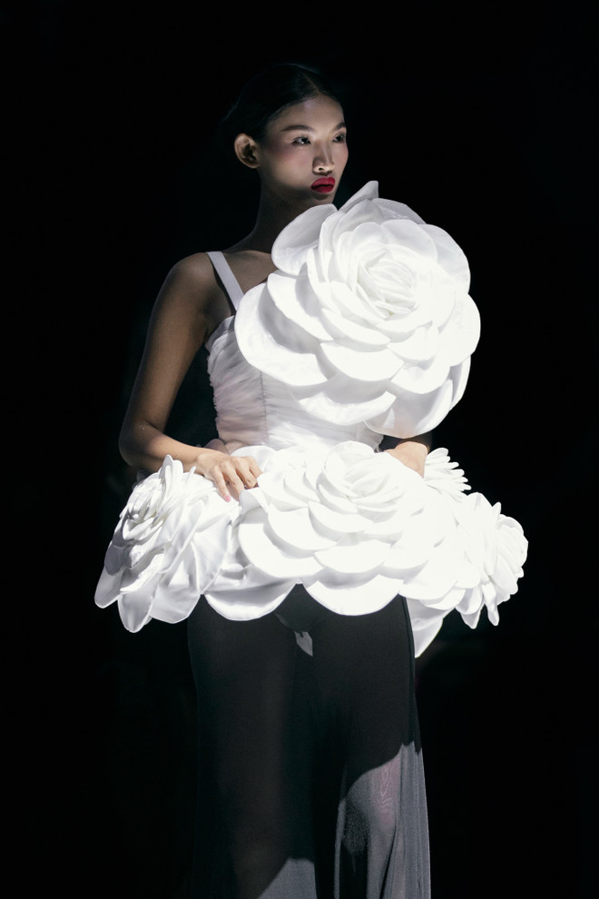 Mở màn cho “White Night” là sự xuất hiện đầy cuốn hút của Quán quân Huỳnh Tú Anh với thiết kế váy dáng dài cùng chiếc áo có phần tùng xòe rộng kết hợp chi tiết bông hoa 3D đầy sống động. (Ảnh: CTV/Vietnam+) 3. Tú Anh diện thiết kế với điểm nhấn là bông hoa nở rộ.jpeg