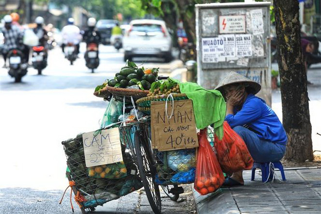 Một người bán hàng rong giữa trưa Hè nóng bức ở Hà Nội. (Ảnh: Tuấn Anh/TTXVN) Bắc Bộ tiếp tục nắng nóng, hai tỉnh Bắc Kạn và Cao Bằng có mưa to ảnh 1