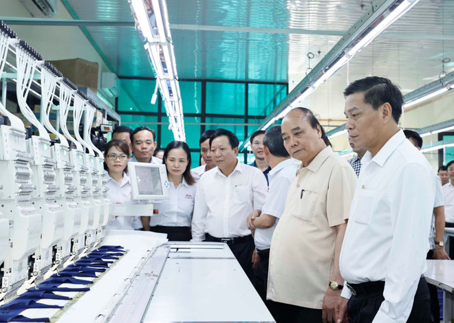 Chủ tịch nước Nguyễn Xuân Phúc thăm các phân xưởng sản xuất tại Công ty trách nhiệm hữu hạn thương mại Sao Mai. (Ảnh: Thống Nhất/TTXVN) Chủ tịch nước thăm mô hình kinh doanh dệt may hiệu quả ở Hải Phòng ảnh 1