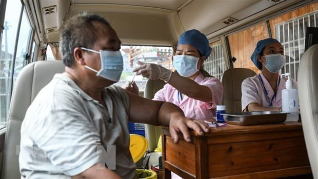 Nhân viên y tế tiêm vaccine ngừa COVID-19 cho người dân tại Quảng Đông, Trung Quốc. (Ảnh: THX/TTXVN) Quảng Đông: Người tiếp xúc gần ca mắc COVID-19 được cách ly tại nhà ảnh 1