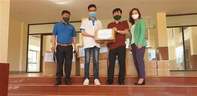 Lê Văn Phúc (áo trắng) trao hàng cho Bộ đội Biên phòng tỉnh Gia Lai hỗ trợ tuyến đầu phòng, chống dịch COVID-19. (Ảnh: TTXVN phát) Chàng sinh viên năm nhất và chiến dịch 'Anh hùng diệt khuẩn' ảnh 2