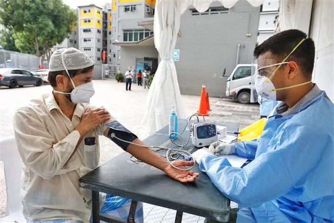 Lao động nước ngoài được kiểm tra y tế tại Singapore ngày 8/4/2020. (Ảnh: THX/TTXVN) Singapore ghi nhận số ca nhiễm mới SARS-CoV-2 cao kỷ lục ảnh 1