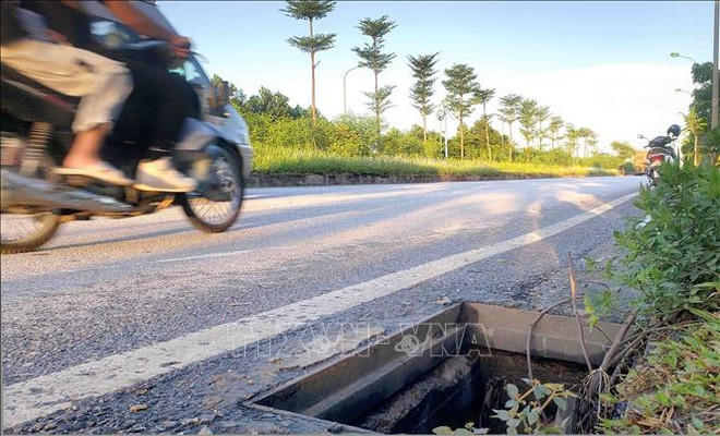 Tình trạng hố ga bị mất nắp trên tuyến đường trục Trung tâm khu đô thị mới Mê Linh đã diễn ra nhiều năm nay nhưng vẫn chưa được khắc phục. (Ảnh tư liệu: Hoàng Hùng/TTXVN) Nguy hiểm từ hàng trăm hố ga bị trộm mất nắp đậy tại Vĩnh Phúc ảnh 1