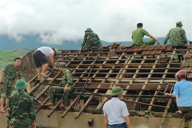 Hơn 250 cán bộ chiến sỹ công an, quân đội có mặt hỗ trợ nhân dân thôn Hoa Tiến (xã Kỳ Hoa, thị xã Kỳ Anh, Hà Tĩnh) lợp lại mái nhà. (Ảnh: Hoàng Ngà/TTXVN) Tập trung khắc phục hậu quả bão số 4, ổn định đời sống nhân dân ảnh 1