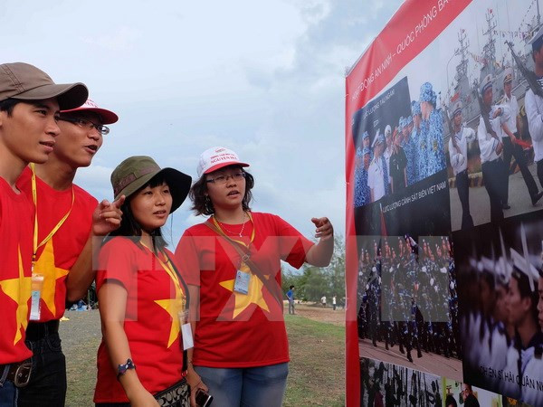 Sinh viên xem ảnh tại triển lãm ảnh 'Tự hào biển đảo Việt Nam.' (Ảnh: Đoàn Bắc/TTXVN) Thanh niên sinh viên kiều bào viết về nhiệm vụ bảo vệ chủ quyền ảnh 1