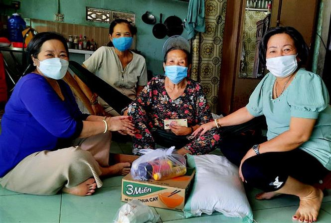 Đại diện Hội Liên hiệp Phụ nữ huyện Giồng Riềng, tỉnh Kiên Giang trao quà hỗ trợ phụ nữ có hoàn cảnh khó khăn bởi dịch COVID-19. (Ảnh: TTXVN phát) Dấu ấn của phụ nữ trong cuộc chiến chống đại dịch COVID-19 ảnh 2