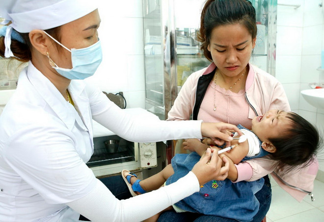 Tiêm vắcxin cho trẻ. (Nguồn: TTXVN) Ho gà có tính lây truyền rất cao, cần tiêm phòng đủ 4 mũi vắcxin ảnh 1