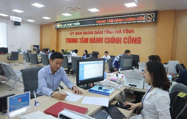Cán bộ Trung tâm hành chính công tỉnh Hà Tĩnh giải quyết thủ tục hành chính cho người dân. (Ảnh minh họa: Hoàng Ngà/TTXVN) Công bố Chỉ số hiệu quả quản trị và hành chính công cấp tỉnh ảnh 1