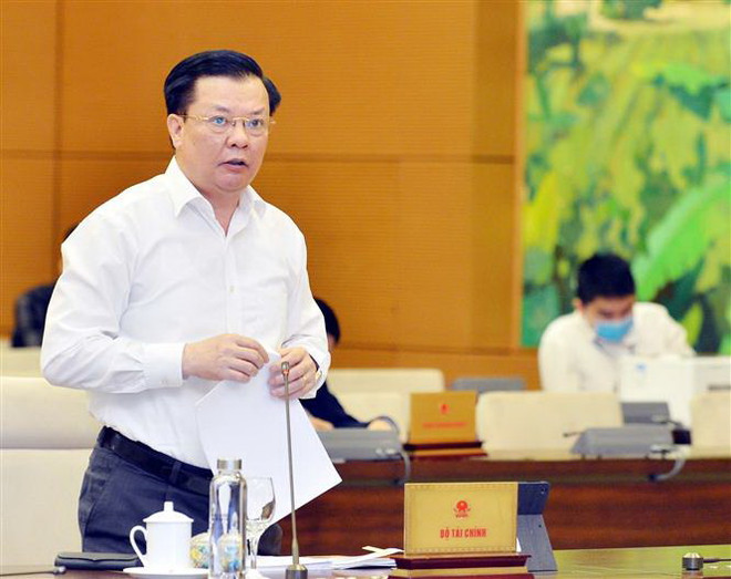 Bộ trưởng Bộ Tài chính Đinh Tiến Dũng trình bày tờ trình về miễn thuế sử dụng đất nông nghiệp. (Ảnh: Trọng Đức/TTXVN) Đề xuất tiếp tục miễn thuế sử dụng đất nông nghiệp đến năm 2025 ảnh 1