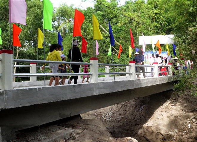 Người dân phấn khởi khi được đi trên cây cầu mới khang trang. (Ảnh: Phước Ngọc/TTXVN) Quảng Ngãi: Xây cầu kiên cố tại vùng thường xuyên bị cô lập vì mưa lũ ảnh 1
