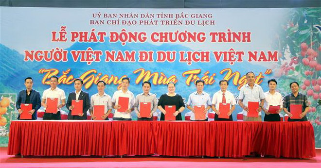 Các doanh nghiệp, cơ sở kinh doanh dịch vụ du lịch tại Bắc Giang ký kết chương trình kích cầu du lịch. (Ảnh: Đồng Thúy/TTXVN) 'Bắc Giang mùa trái ngọt' - điểm đến hấp dẫn khách du lịch ảnh 1