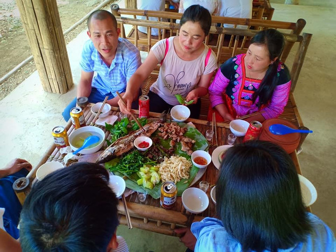 Du khách thích thú thưởng thức đặc sản địa phương. (Ảnh: Vietnam+) Bài 2 - Du lịch Đà Bắc: Diện mạo mới từ những ‘hạt giống’ đầu tiên ảnh 2