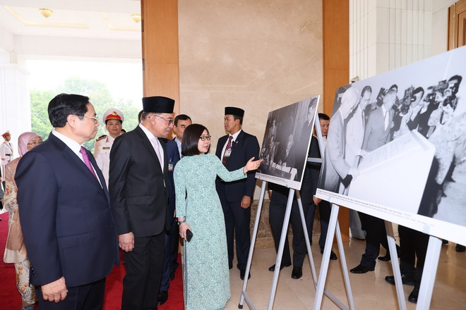 Thủ tướng Phạm Minh Chính và Thủ tướng Malaysia Anwar Ibrahim tham quan trưng bày ảnh của Thông tấn xã Việt Nam. (Ảnh: Dương Giang/TTXVN) Thủ tướng Malaysia Anwar Ibrahim kết thúc tốt đẹp chuyến thăm Việt Nam ảnh 1
