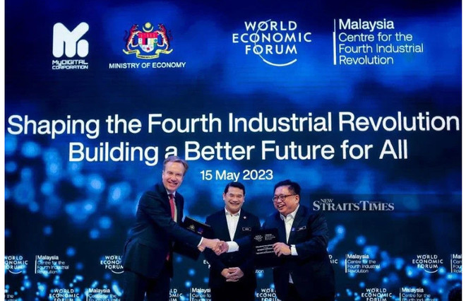 Bộ trưởng Kinh tế, Rafizi Ramli (giữa) chứng kiến chủ tịch Diễn đàn Kinh tế Thế giới, Børge Brende (trái) trao đổi tài liệu với giám đốc điều hành MyDigital, Fabian Bigar (phải) trong buổi ra mắt Trung tâm Cách mạng Công nghiệp lần thứ tư Malaysia tại Trung tâm Hội nghị Kuala Lumpur (Ảnh: Nguồn NSTP Malaysia thành lập Trung tâm Cách mạng Công nghiệp lần thứ 4 ảnh 1