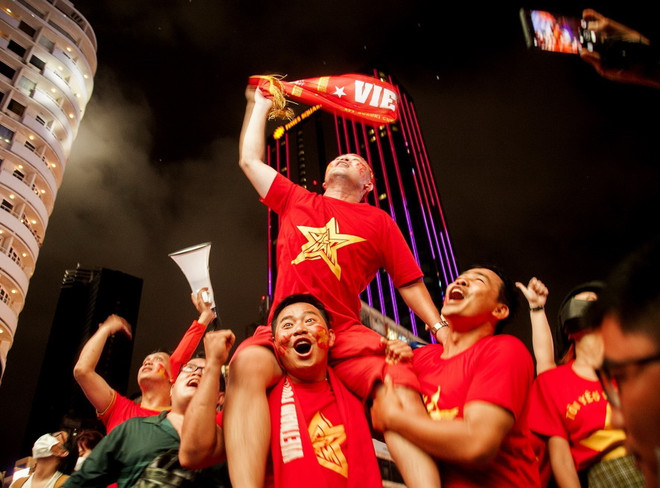 Người hâm mộ Thành phố Hồ Chí Minh ăn mừng chiến thắng của U23 Việt Nam. (Ảnh: Hồng Đạt/TTXVN) TP.HCM rợp màu cờ Tổ quốc trong đêm chiến thắng của U23 Việt Nam ảnh 1