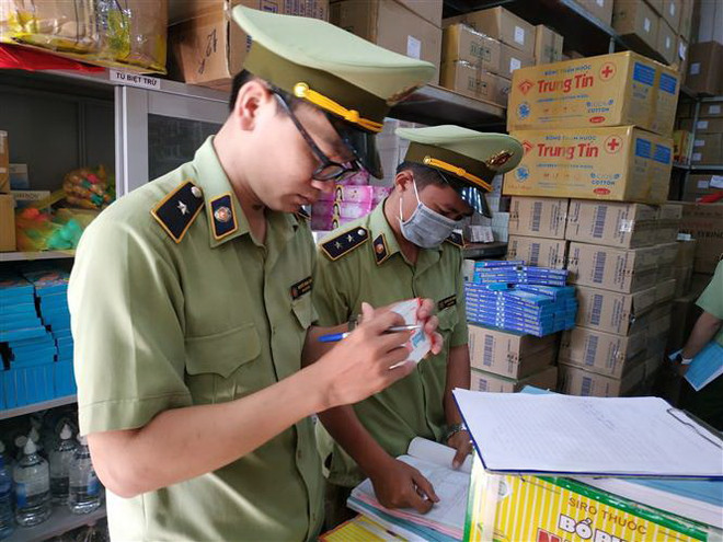 Lực lượng chức năng kiểm tra các cơ sở kinh doanh. (Ảnh: Tuấn Anh/TTXVN) Đã kiểm tra, xử lý hơn 4.500 vụ vi phạm về khẩu trang, nước sát khuẩn ảnh 1