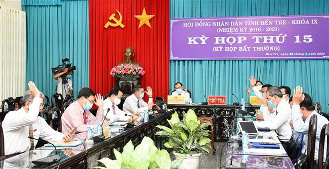 Đại biểu HĐND tỉnh biểu quyết thông qua Nghị quyết kỳ họp. (Ảnh: Công Trí/TTXVN) HĐND tỉnh Bến Tre họp trực tuyến, thông qua 11 nghị quyết quan trọng ảnh 1