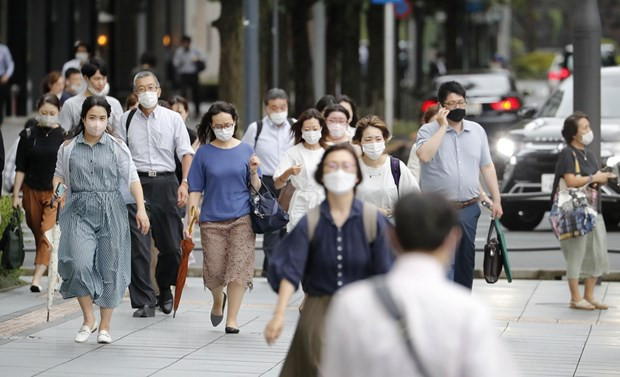 Người dân đeo khẩu trang phòng dịch COVID-19 tại Tokyo, Nhật Bản, ngày 13/7/2022. (Ảnh: Kyodo/TTXVN) Nhật Bản cấp chứng nhận tiêm vaccine COVID-19 ở các cửa hàng tiện lợi ảnh 1