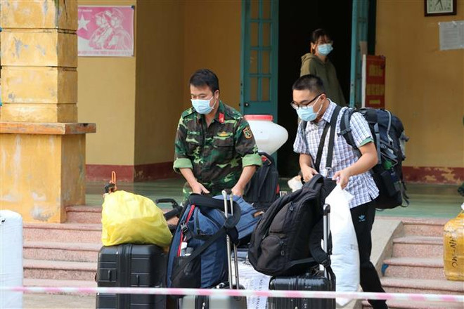 Cán bộ chiến sỹ Trung đoàn 814 giúp công dân vận chuyển đồ cá nhân tại khu cách ly. (Ảnh: Thanh Hải/TTXVN) Việt Nam ghi nhận 3 ca mắc COVID-19, được cách ly ngay khi nhập cảnh ảnh 1