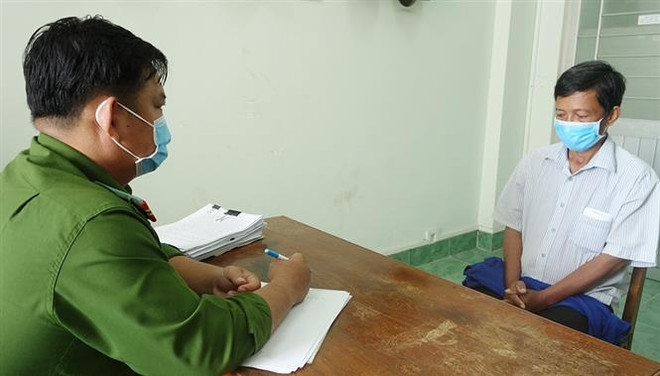 Phan Ngọc Phương (bìa phải) tại cơ quan điều tra. (Ảnh: TTXVN phát) An Giang: Khởi tố nguyên cán bộ địa chính xã chiếm đoạt 3,1 tỷ đồng ảnh 1