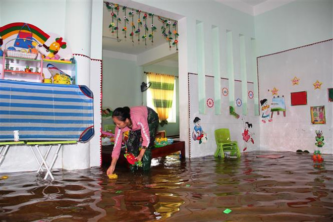 Giáo viên mầm non dọn dẹp lại trường lớp. (Ảnh: Hoàng Ngà/TTXVN) Chuyện về những cô giáo trắng đêm cứu tài sản của nhà trường trong lũ ảnh 2