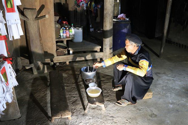 Nghi lễ cúng tổ tiên, xua đuổi cái xấu tại một gia đình ở xã Làng Chếu, huyện Bắc Yên. (Ảnh: Hữu Quyết/TTXVN) Sơn La: Lên vùng cao Bắc Yên đón Tết cùng đồng bào Mông ảnh 1