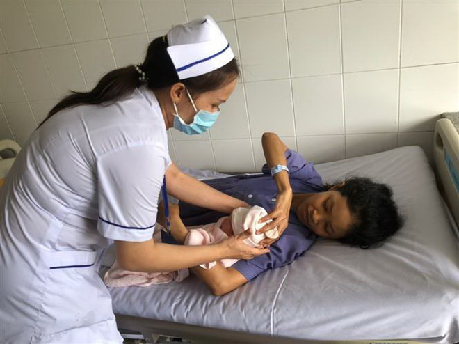 Chăm sóc sản phụ và em bé sau phẫu thuật. (Ảnh: TTXVN) Cần Thơ: Cứu sống sản phụ mắc bệnh tim bẩm sinh kèm hen phế quản ảnh 1