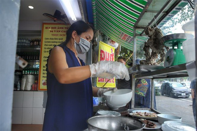 Một cửa hàng phở trên phố Văn Cao (Ba Đình) mở cửa phục vụ khách mua mang về. (Ảnh: Tuấn Đức/TTXVN) Nhiều hộ kinh doanh ở Hà Nội vui mừng khi được hoạt động trở lại ảnh 2