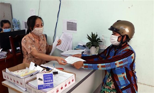 Chi trả kinh phí cho người thuộc diện được hỗ trợ. (Ảnh: Công Thử/TTXVN) Hỗ trợ 118.000 tỷ đồng cho doanh nghiệp, người dân bị tác động vì dịch ảnh 2