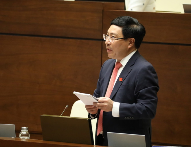 Phó Thủ tướng, Bộ trưởng Bộ Ngoại giao Phạm Bình Minh giải trình ý kiến của đại biểu Quốc hội. (Ảnh: Văn Điệp/TTXVN) Cân nhắc mở rộng chủ thể ký kết thỏa thuận quốc tế đến cấp huyện, xã ảnh 1