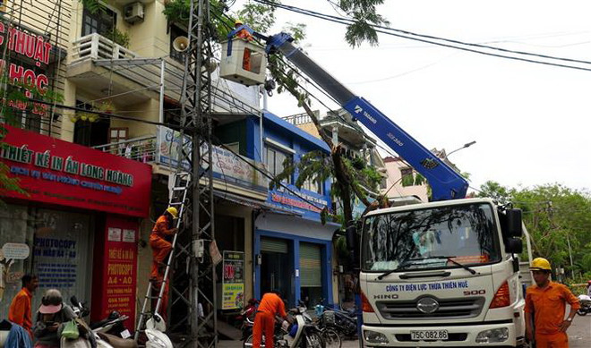 Công nhân đang sửa chữa điện tại thành phố Huế. (Ảnh: Tường Vi/TTXVN) Hỗ trợ người dân khắc phục nhanh hậu quả của cơn bão số 5 ảnh 1