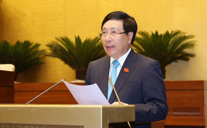 Phó Thủ tướng Chính phủ, Bộ trưởng Bộ Ngoại giao Phạm Bình Minh trình bày Tờ trình về dự án Luật Thỏa thuận quốc tế. (Ảnh: Phương Hoa/TTXVN) Tạo cơ sở cho việc thể chế hóa đường lối, chủ trương hội nhập quốc tế ảnh 1