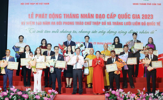 Chủ tịch nước Võ Văn Thưởng, Chủ tịch danh dự Hội Chữ thập Đỏ Việt Nam và bà Bùi Thị Hòa, Chủ tịch Hội Chữ thập Đỏ Việt Nam tặng hoa và trao bảng Ghi nhận tấm lòng vàng nhân đạo. (Ảnh: Thống Nhất/TTXVN) Chủ tịch nước: Đồng hành với Hội Chữ thập Đỏ trợ giúp người nghèo ảnh 3