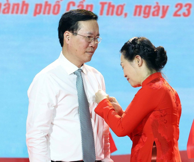 Bà Bùi Thị Hòa - Chủ tịch Hội Chữ thập Đỏ Việt Nam - gắn Huy hiệu Chữ thập Đỏ và tặng hoa chúc mừng Chủ tịch nước Võ Văn Thưởng làm Chủ tịch danh dự Hội Chữ thập Đỏ Việt Nam. (Ảnh: Thống Nhất/TTXVN) Chủ tịch nước: Đồng hành với Hội Chữ thập Đỏ trợ giúp người nghèo ảnh 2