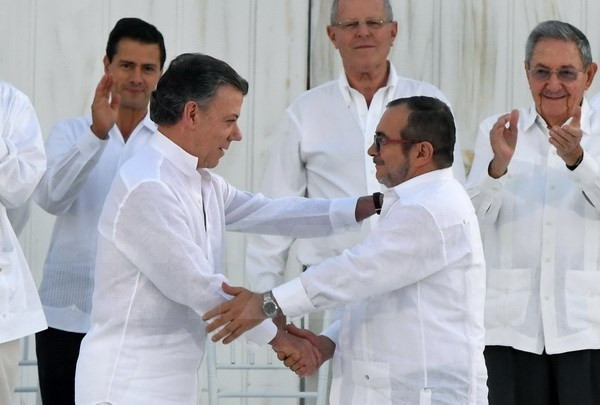 Tổng thống Colombia Juan Manuel Santos (thứ 2, trái) và thủ lĩnh FARC Timoleon Jimenez (thứ 2, phải) tại lễ ký kết thỏa thuận hòa bình ở Cartagena, Colombia ngày 26/9. (Nguồn: AFP/TTXVN) Chính phủ Colombia và FARC chuẩn bị ký thỏa thuận hòa bình mới ảnh 1