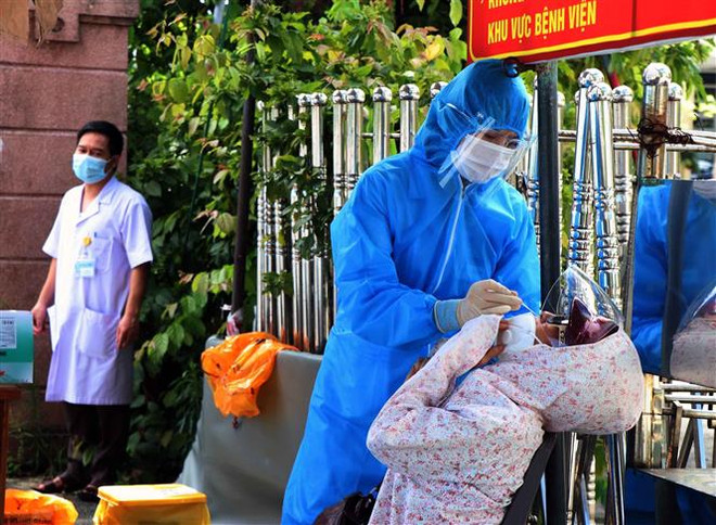 Người dân chờ được xét nghiệm nhanh trước khi vào khám, điều trị tại bệnh viện. (Ảnh: Công Tường/TTXVN) Việt Nam có tổng cộng 272 ca mắc mới COVID-19 trong ngày 14/6 ảnh 2