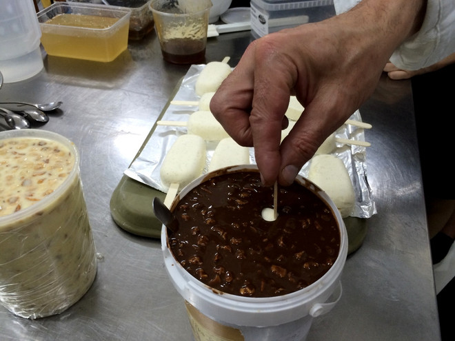Phủ hỗn hợp cacao với hạt phỉ cho kem Eskimo thơm ngon, hấp dẫn. (Ảnh: Xuân Mai/Vietnam+) Bậc thầy thế giới về nghệ thuật làm kem trổ tài tại thủ đô Hà Nội ảnh 8