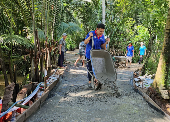 Sinh viên trường Đại học Hoa Sen (Thành phố Hồ Chí Minh) hỗ trợ người dân xã Tân Lợi Thạnh (Giồng Trôm, Bến Tre) làm tuyến đường giao thông nông thôn. (Ảnh: Chương Đài/TTXVN) ttxvn-mua he xanh 2.jpg