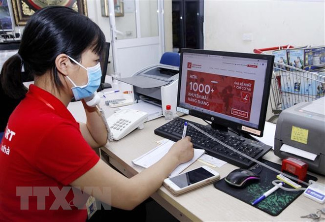 Nhân viên siêu thị nhận cuộc gọi mua hàng online từ khách hàng. (Ảnh minh họa: Hoàng Hùng/TTXVN) Chuyên gia Hong Kong: Việt Nam là thị trường tiêu dùng hấp dẫn ảnh 1