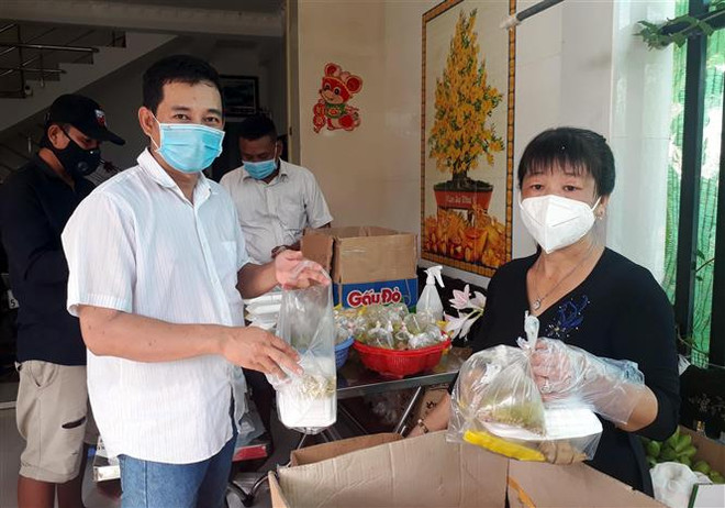 Anh Trần Phước Lành và vợ là chị Huỳnh Thị Thu Hằng chuẩn bị 130 phần cơm hỗ trợ người dân cách ly tập trung mỗi ngày. (Ảnh: TTXVN phát) Sóc Trăng: Cặp vợ chồng chung sức nấu cơm hỗ trợ người ở khu cách ly ảnh 1