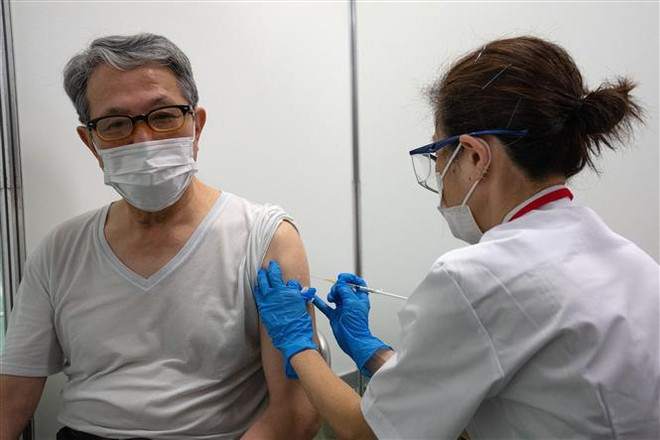 Tiêm vaccine ngừa COVID-19 cho người dân tại Tokyo, Nhật Bản ngày 24/5/2021. (Ảnh: AFP/TTXVN) Sự thất thế trong cuộc đua vaccine làm ảnh hưởng đến kinh tế châu Á ảnh 1