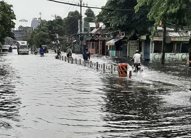 'Biển nước' mênh mông trên đường Lê Đức Thọ, quận Gò Vấp. (Ảnh: Hồng Giang/TTXVN) TP.HCM mưa to, nhiều phương tiện bị chết máy giữa 'biển nước' ảnh 1