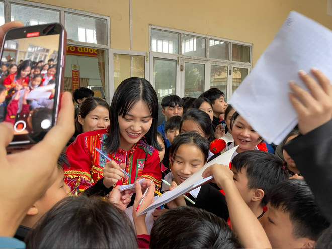 Nông Thúy Hằng trong vòng vây người hâm mộ ở "làng Địa Ngục." (Ảnh: CTV/Vietnam+) Hoa hau Nong Thuy Hang duoc dong dao hoc sinh huyen Bac Me xin chu ki.JPG