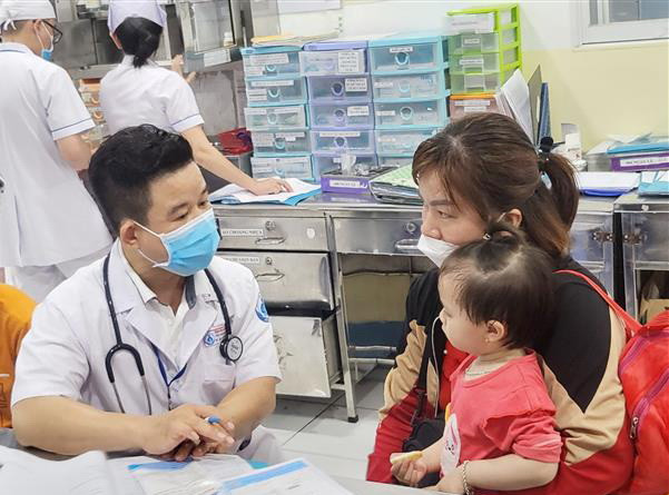Khám cho trẻ mắc bệnh tay chân miệng. (Ảnh: TTXVN phát) Số ca mắc bệnh tay chân miệng ở Thành phố Hồ Chí Minh giảm nhẹ ảnh 1