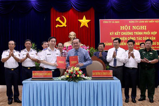 Thiếu tướng Bùi Quốc Oai, Bí thư Đảng ủy Bộ Tư lệnh Cảnh sát biển Việt Nam và ông Phạm Bạch Đằng, Phó Bí thư Thường trực Tỉnh ủy Cà Mau ký kết Chương trình phối hợp thực hiện công tác dân vận 'Cảnh sát biển đồng hành với ngư dân'' tại buỗi lễ. (Ảnh: Kim Há/TTXVN) Ký kết chương trình cảnh sát biển đồng hành với ngư dân Cà Mau ảnh 1