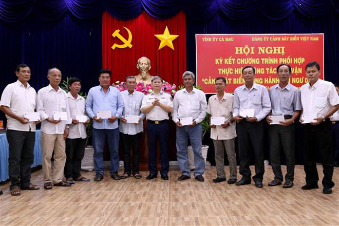 Trung tướng Nguyễn Văn Sơn, Phó Bí thư Đảng ủy Tư Lệnh Cảnh sát biển Việt Nam tặng quà cho ngư dân Cà Mau tại buổi lễ. (Ảnh: Kim Há/TTXVN) Ký kết chương trình cảnh sát biển đồng hành với ngư dân Cà Mau ảnh 2