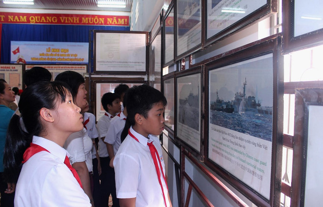 Học sinh tham quan một triển lãm về Hoàng Sa, Trường Sa. (Nguồn: TTXVN) Triển lãm bản đồ và tư liệu về Hoàng Sa, Trường Sa của Việt Nam ảnh 1