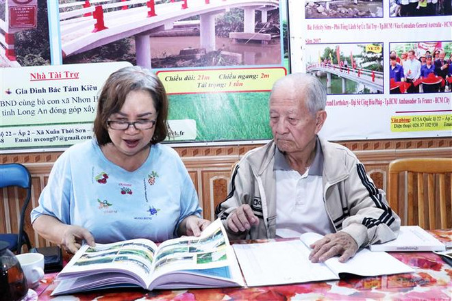 Ông Nguyễn Văn Công (phải) và bà Nguyễn Thị Mỹ Linh (trái), những người sáng lập nhóm VK tuy tuổi đã cao nhưng vẫn nhiệt huyết với hoạt động thiện nguyện xây cầu nông thôn. (Ảnh: Xuân Khu/TTXVN) Kiều bào Việt Nam và những cây cầu kết nối quê hương ảnh 3