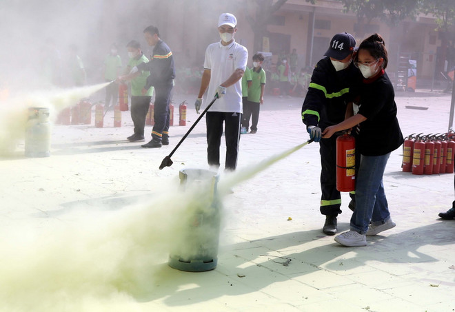 Hướng dẫn học sinh thực hành chữa cháy bằng bình chữa cháy mini. (Ảnh: Văn Đạt/TTXVN) ttxvn_phong chay.jpg