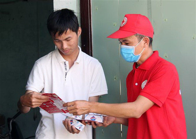 Hội viên Hội Chữ thập Đỏ thành phố Đà Nẵng đến tận nhà dân phát tờ rơi tuyên truyền và xà phòng miễn phí. (Ảnh: Văn Dũng/TTXVN) Đà Nẵng không tổ chức Lễ hội Pháo hoa quốc tế để phòng dịch COVID-19 ảnh 1